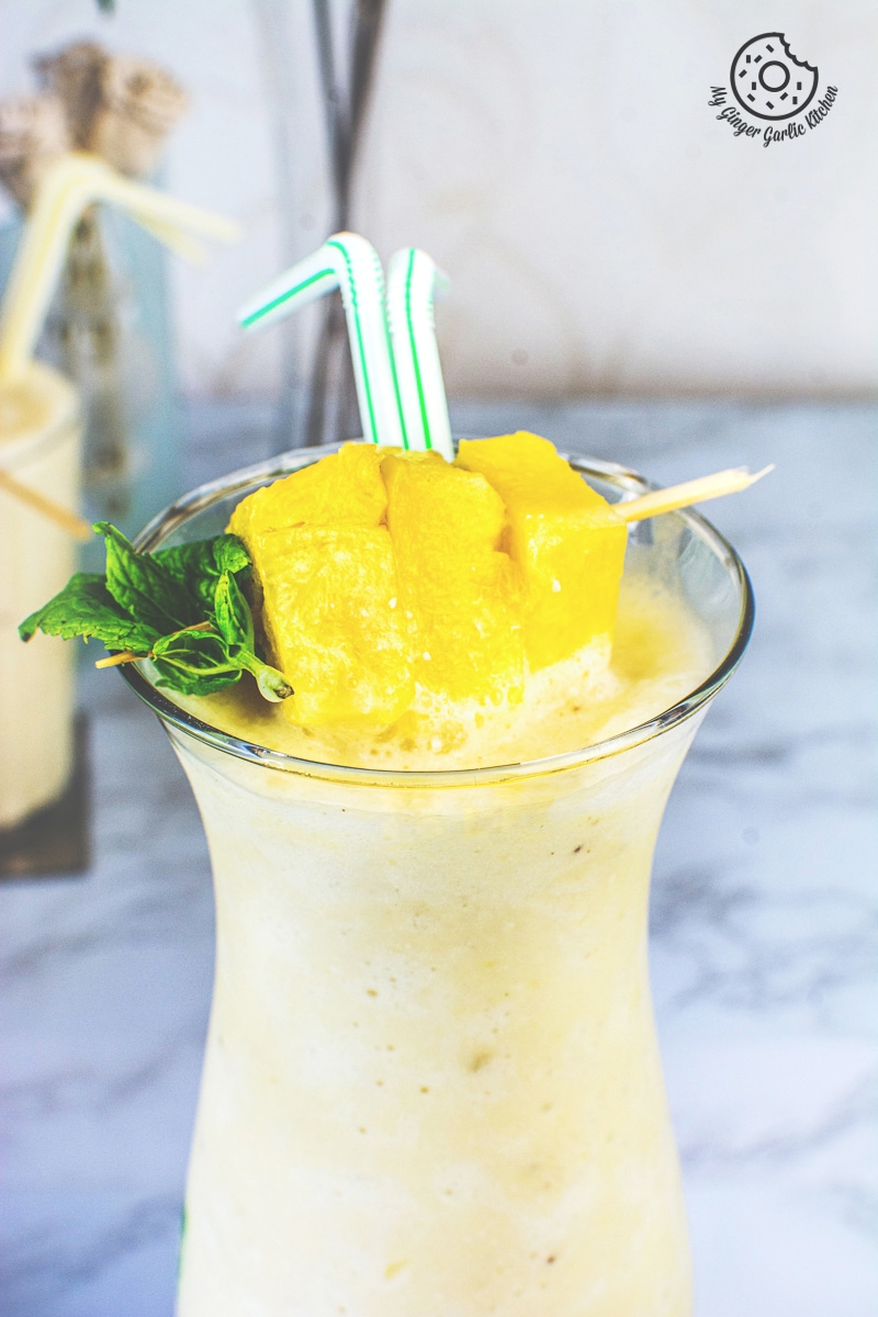 pineapple coconut smoothie with pineapple chunks and yellow straws