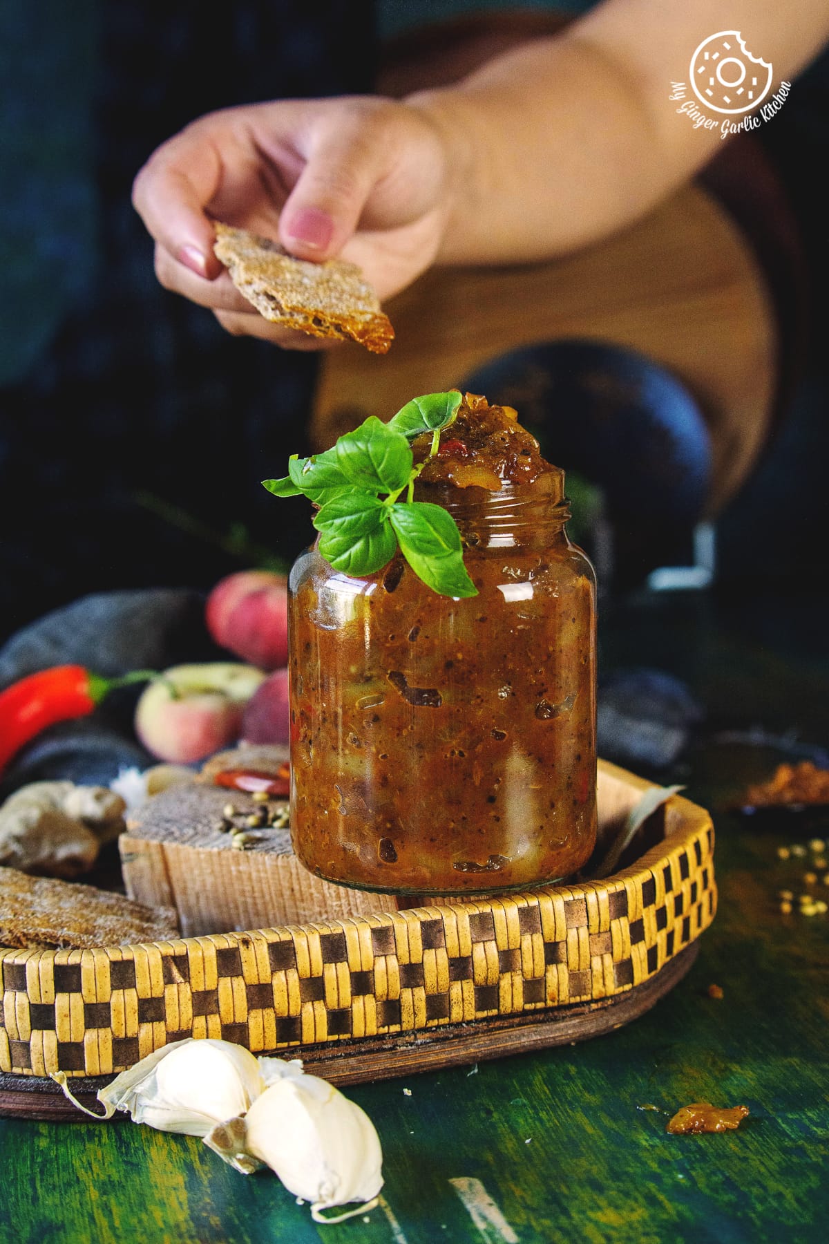 peach chutney in a glass jar and a hand in background