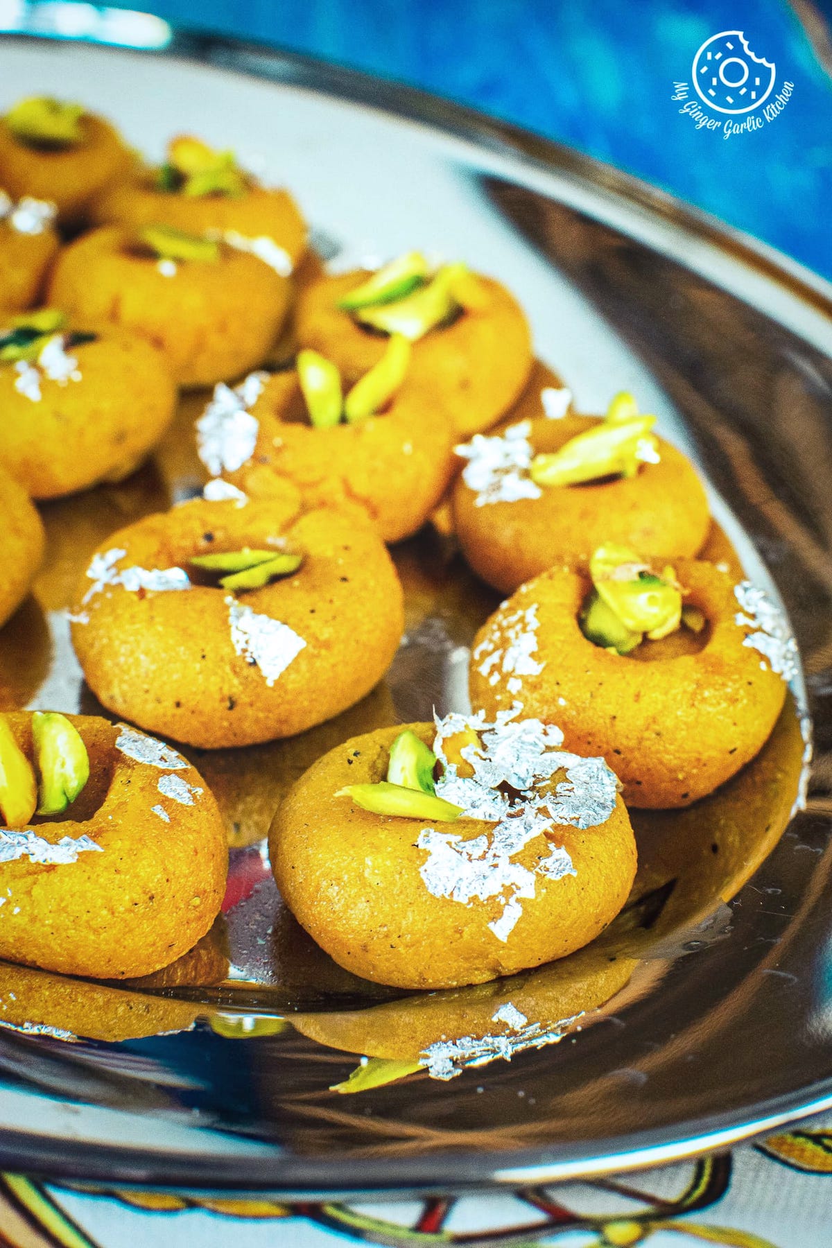 mango peda garnished with edible sliver leaves and pistachios