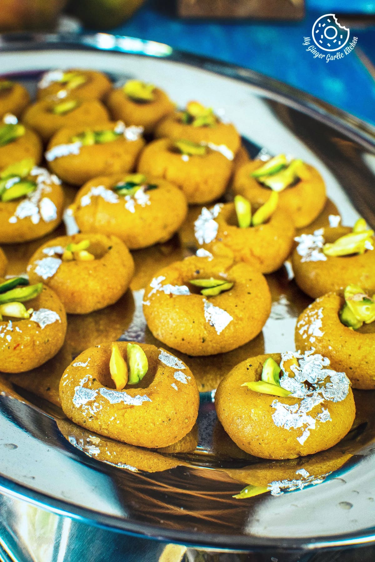 mango peda edible sliver leaves and pistachios served in a steel tray