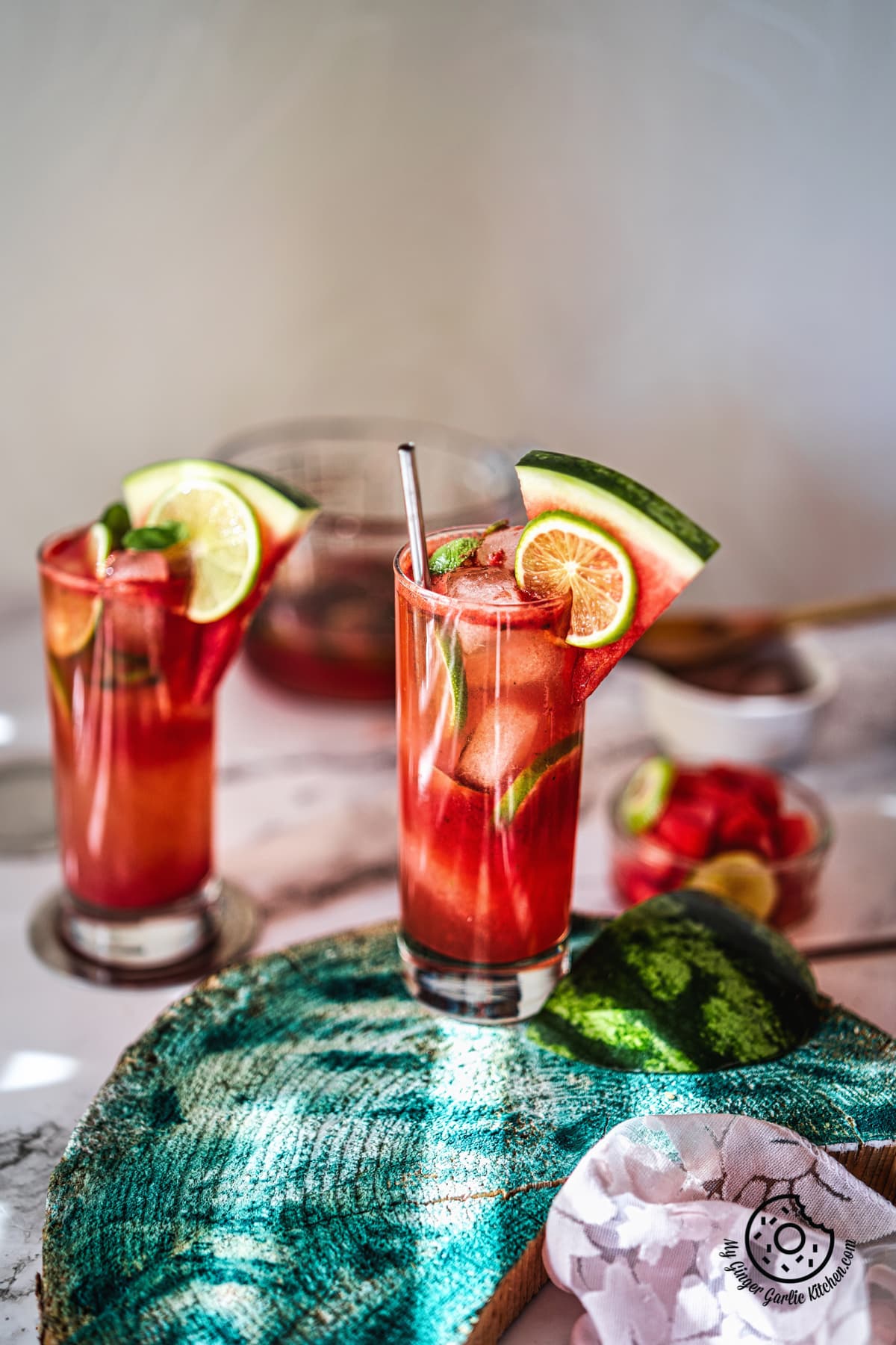 two watermelon mojito glasses decoarated with lime and watermelon slice