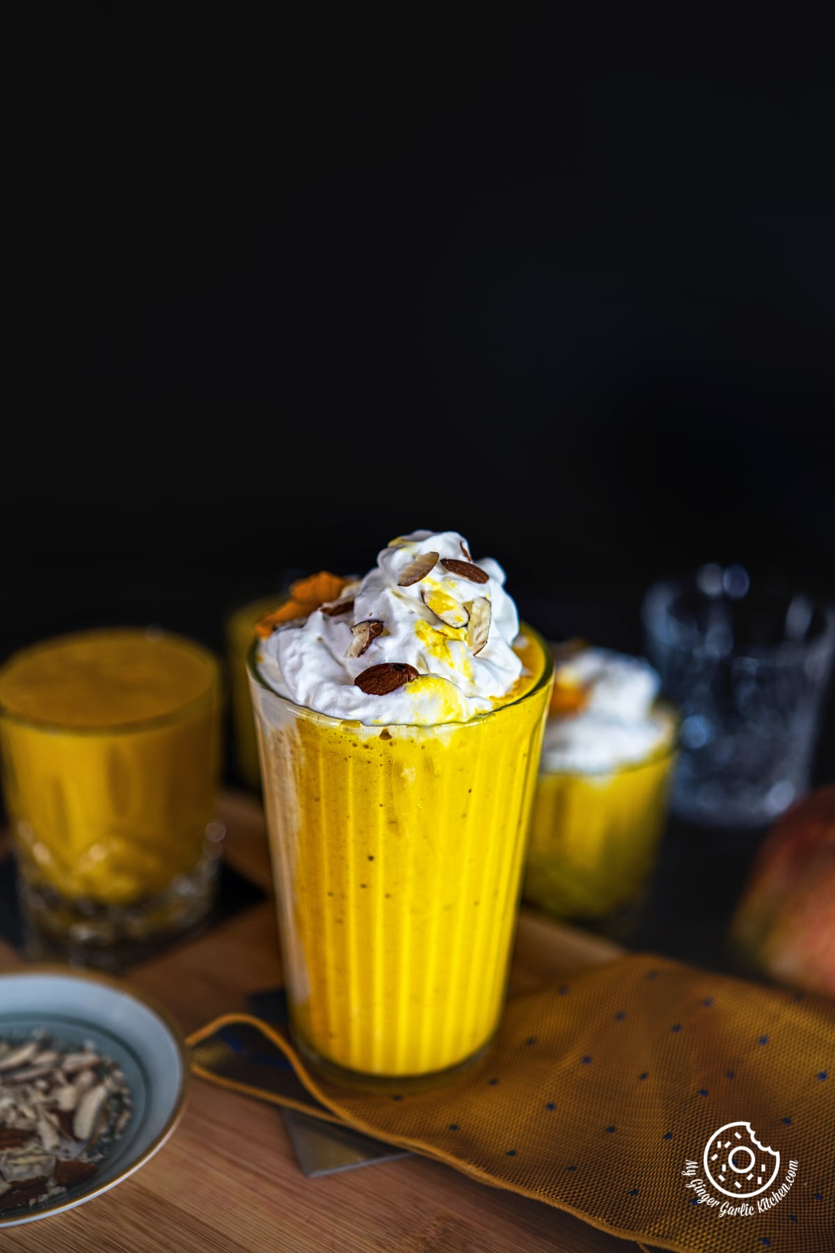 mango milkshake topped with whipped cream and nuts