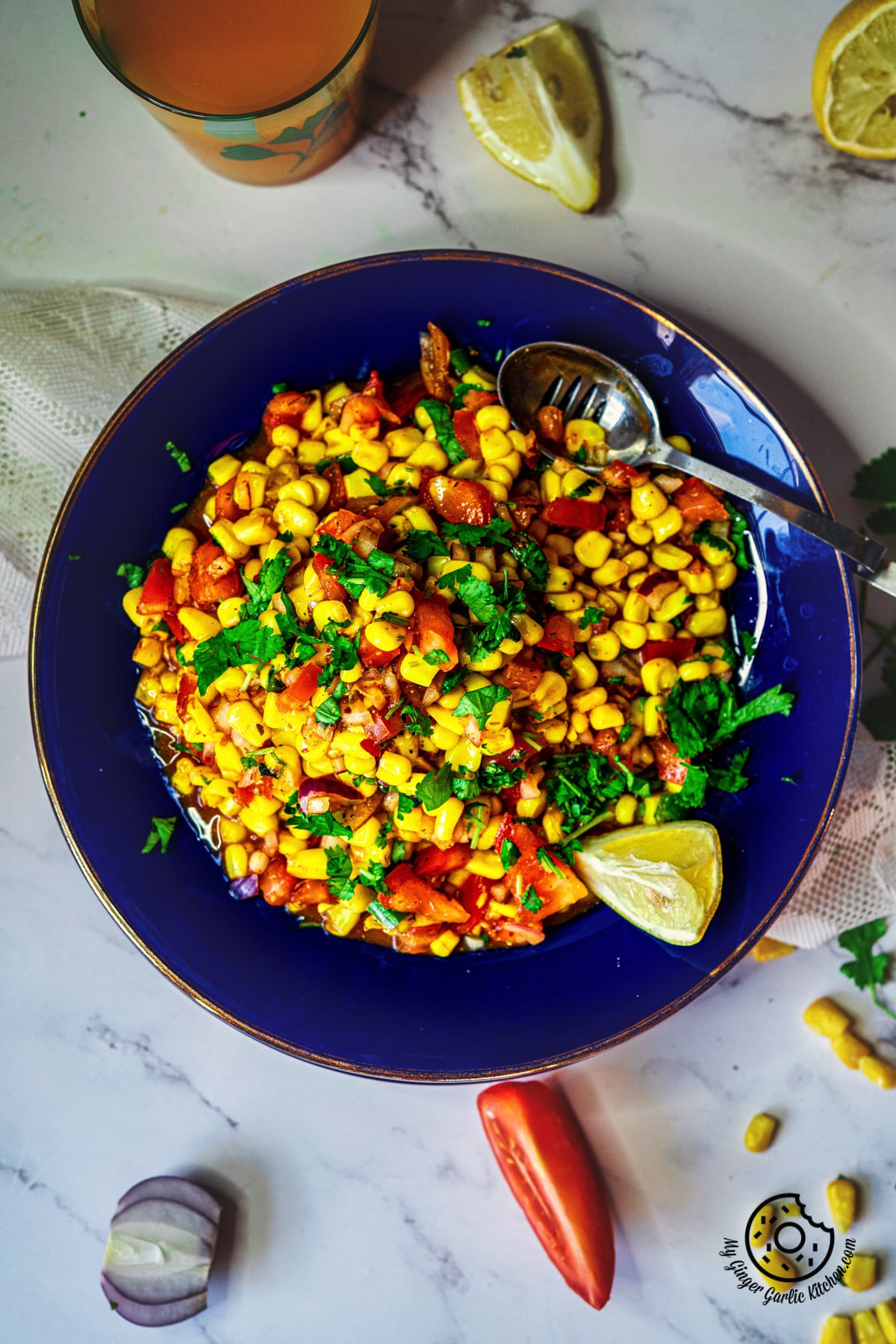 Corn Chaat Recipe. Overhead closeup shot of corn chaat served in a blue plate