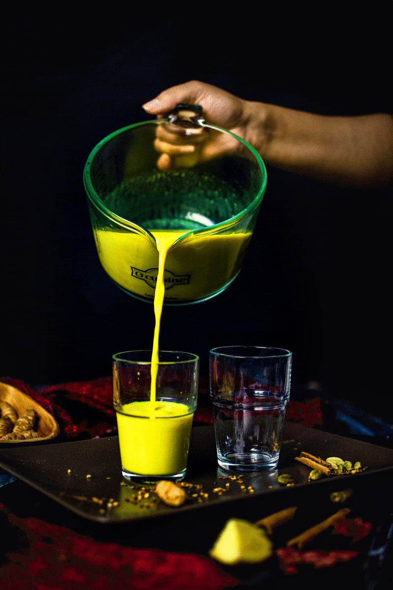 pouring image shot of golden milk (haldi doodh)