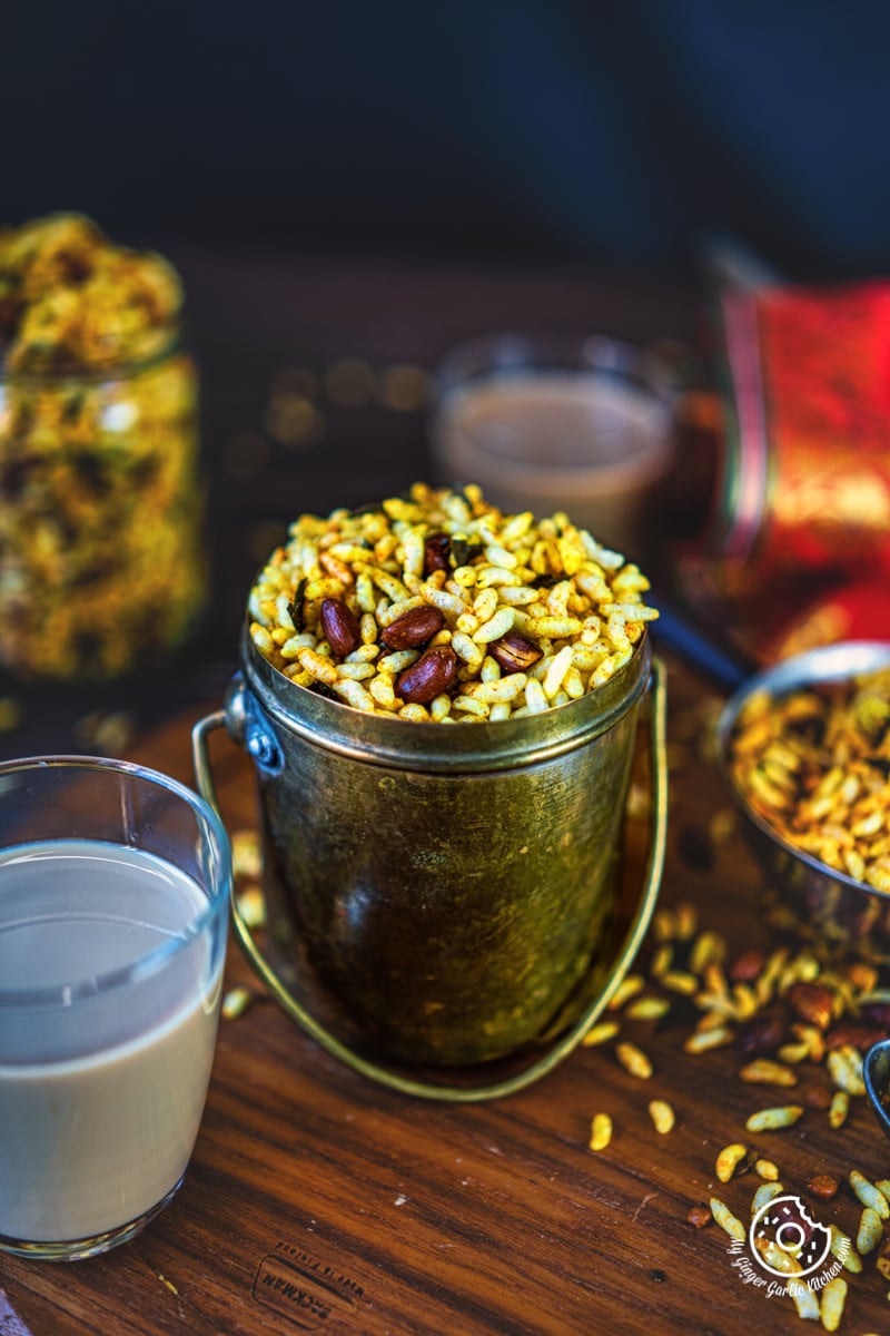 murmura chivda | spicy puffed rice | murmura namkeen in a an antique brass pot and a coffee glass on the side