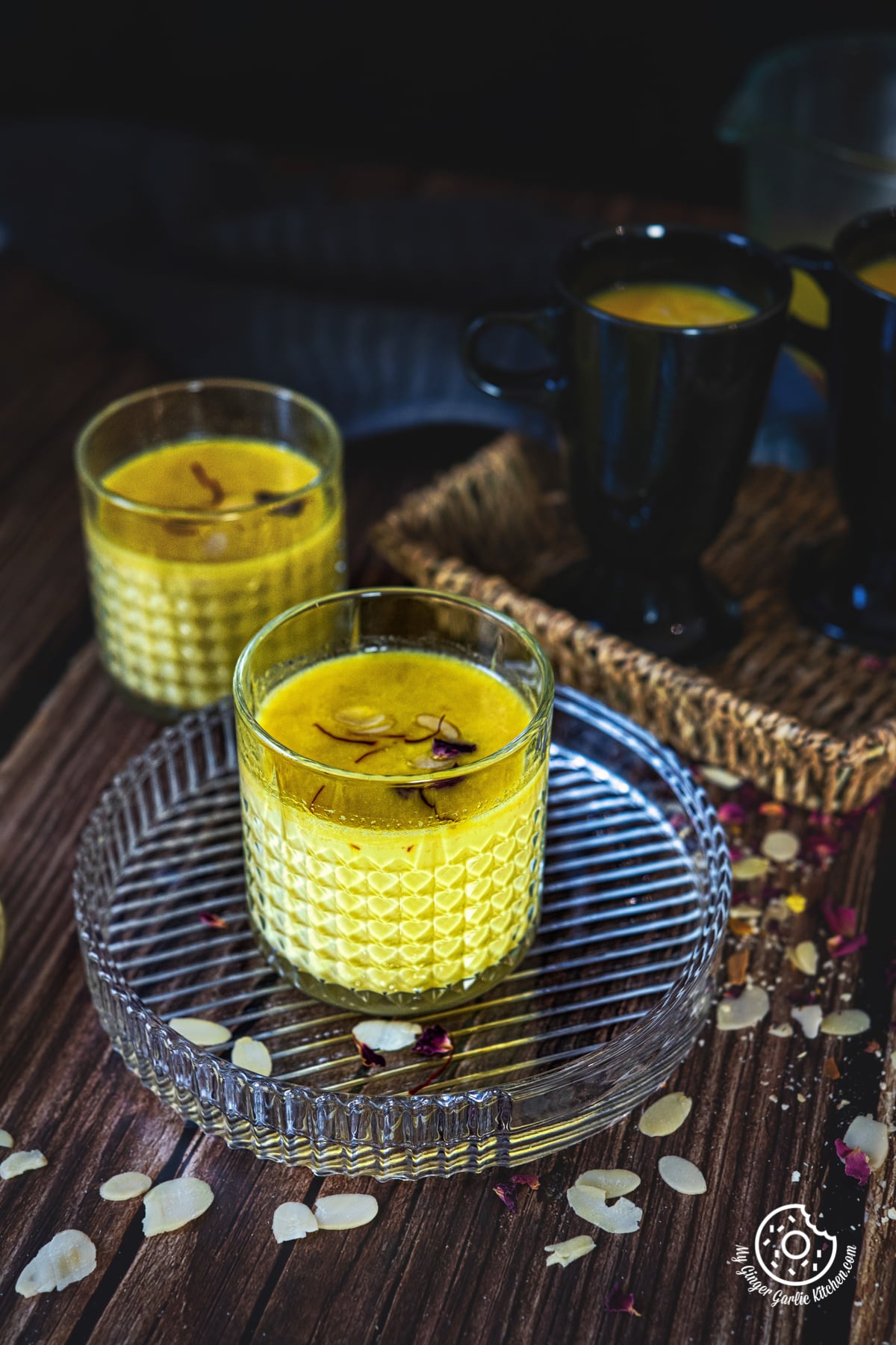 saffron milk in a transparent glass and one more glass in the background