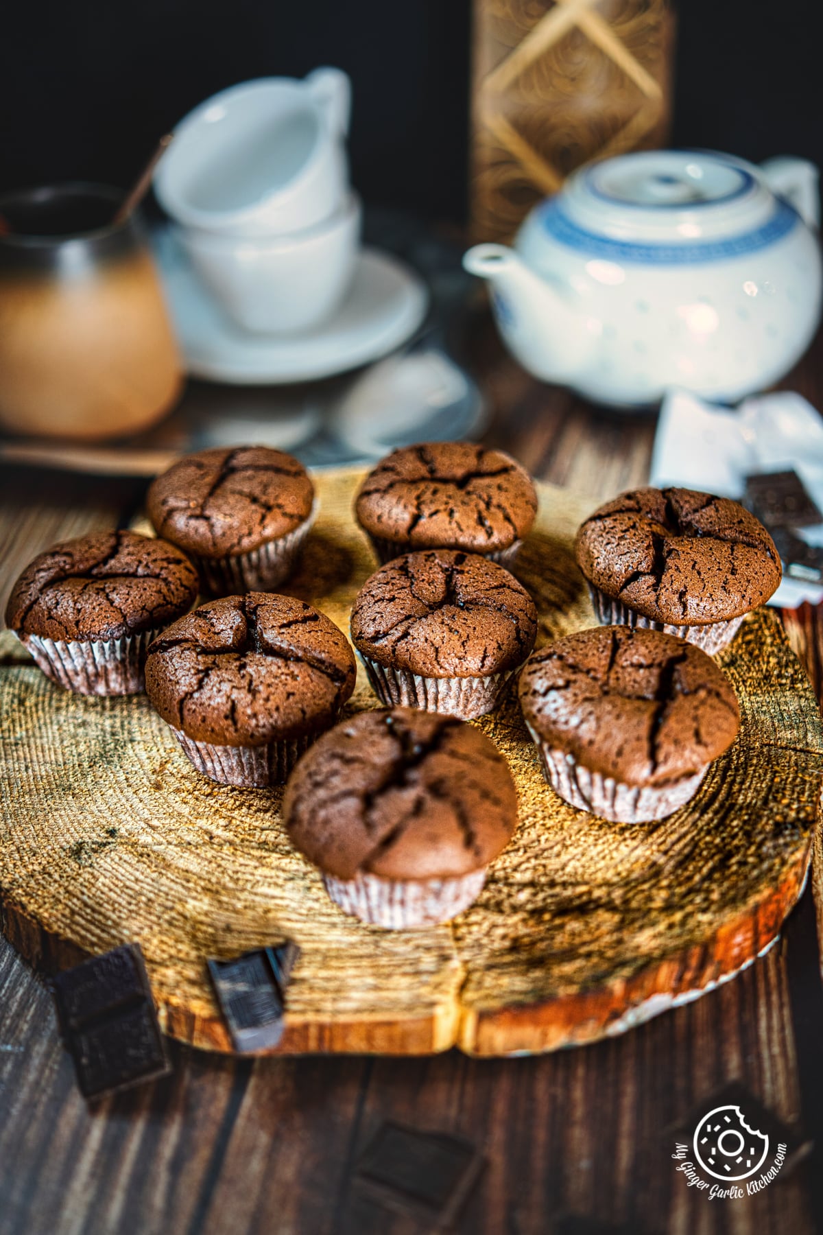 seven pieces of 2 ingredient chocolate muffins on a natural wooden log with some chocolate pieces on the side