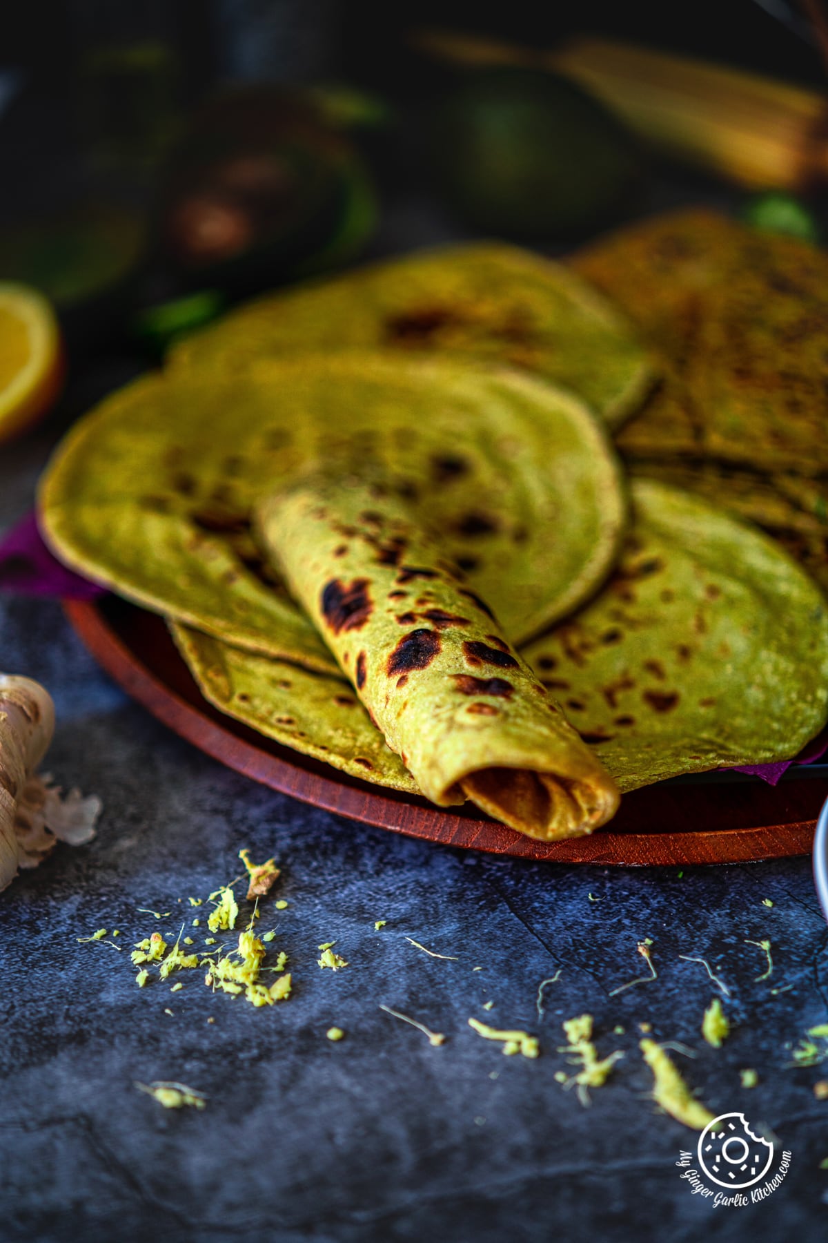 avocado parathas and avocado rotis in a wooden plate with some curry on the side
