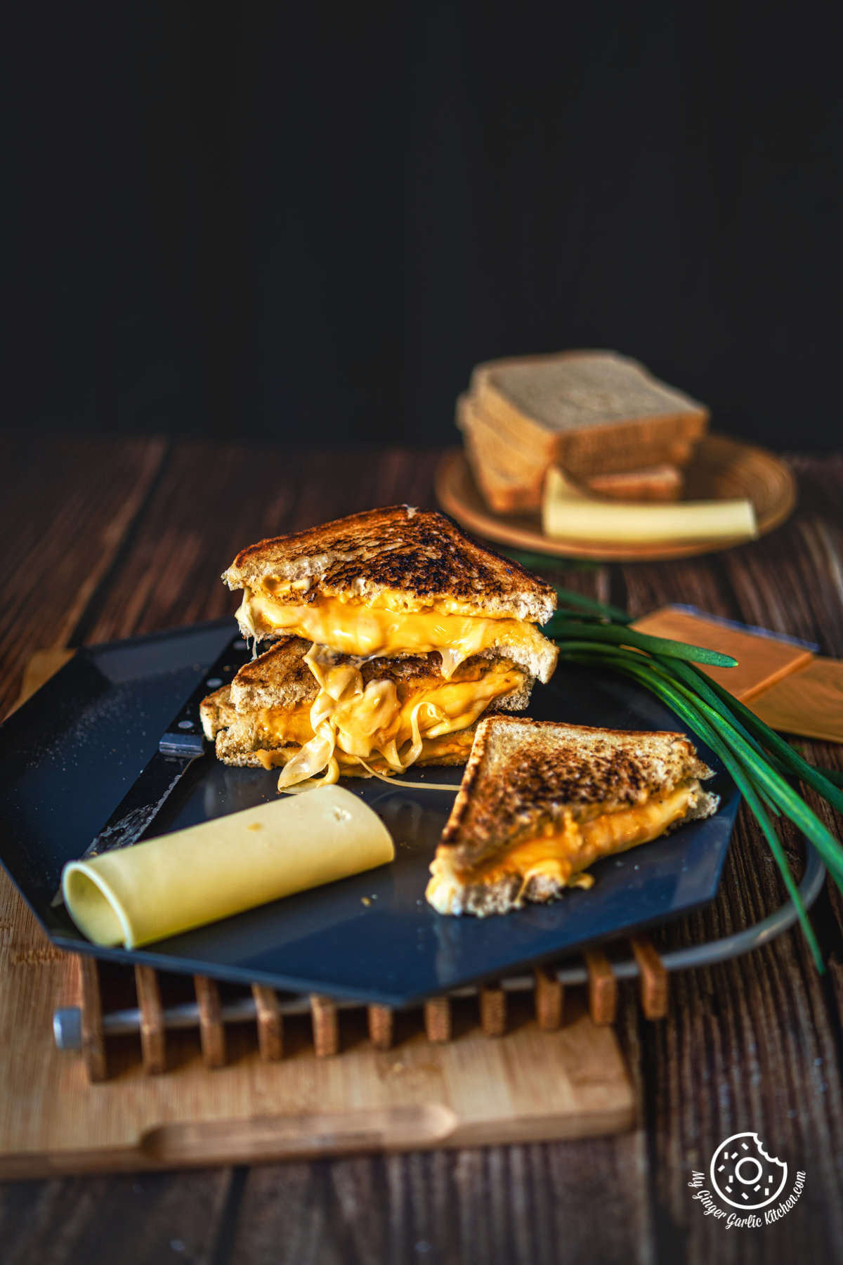 Stacked Grilled Cheese Sandwich cut in half showing melting cheesy center with one grilled cheese sandwich on the side