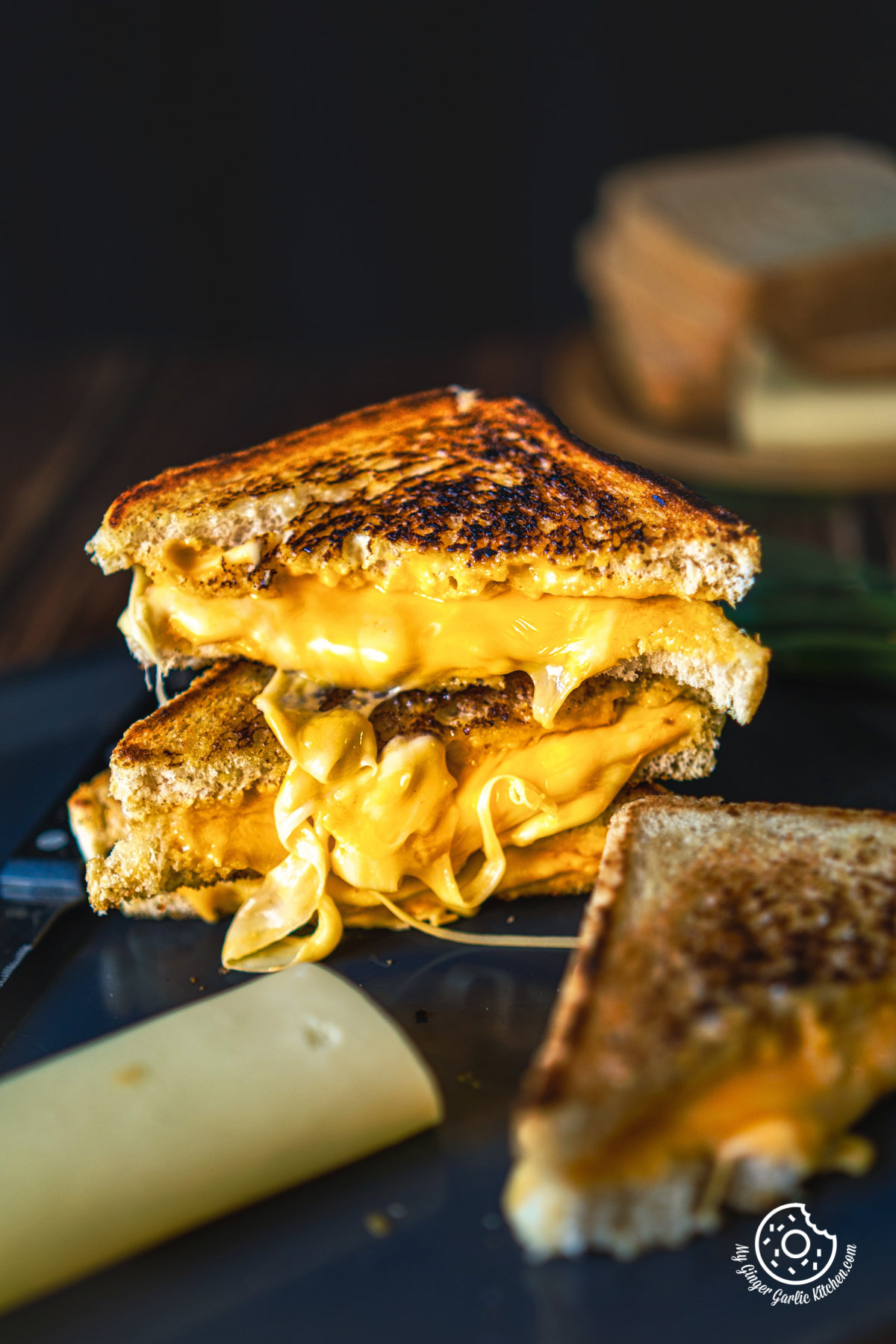 Closeup shot of stacked Grilled Cheese Sandwich cut in half showing melty cheese inside of a grilled cheese sandwich