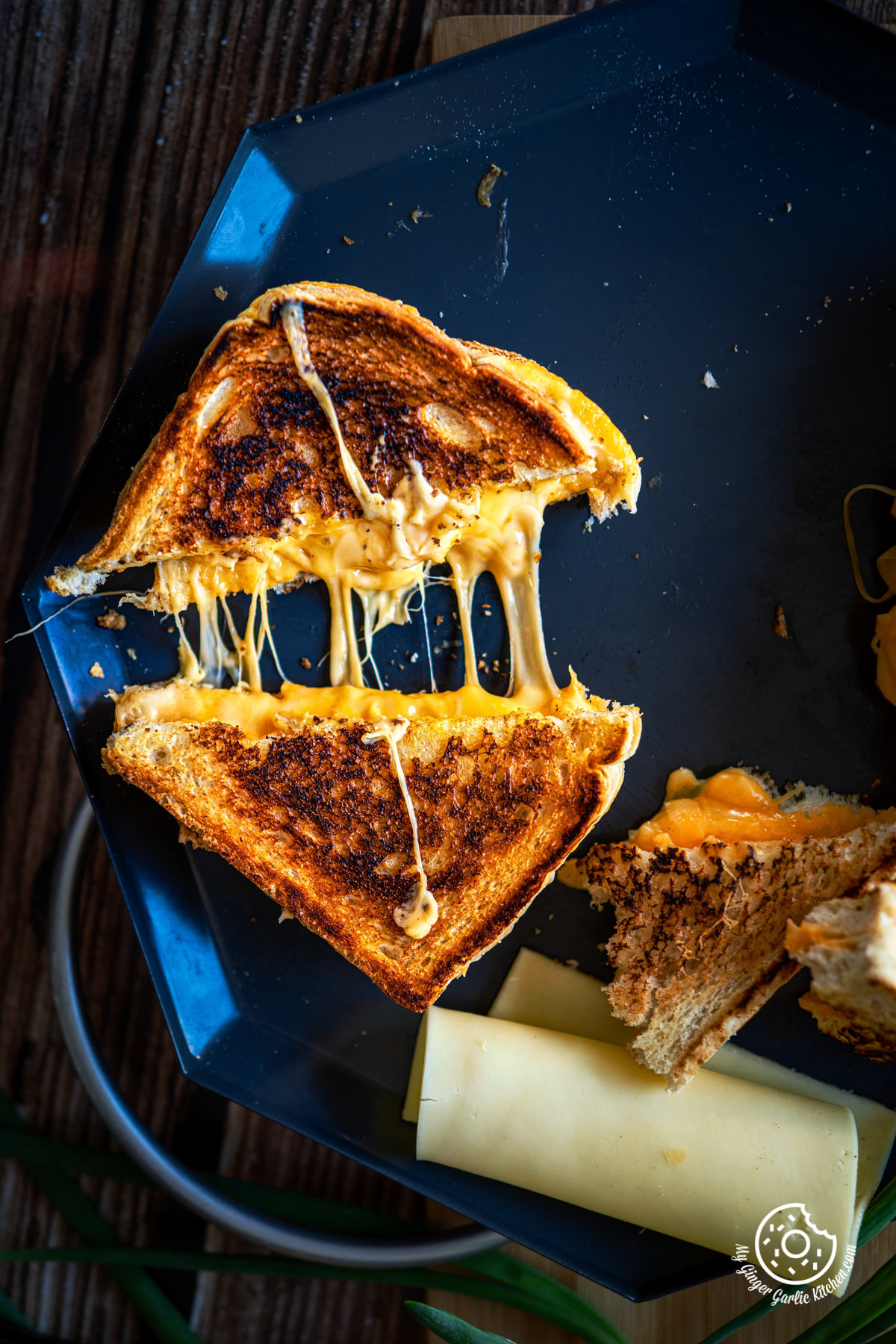 overhead shot of grilled cheese sandwich cut in half showing stringy melting chees