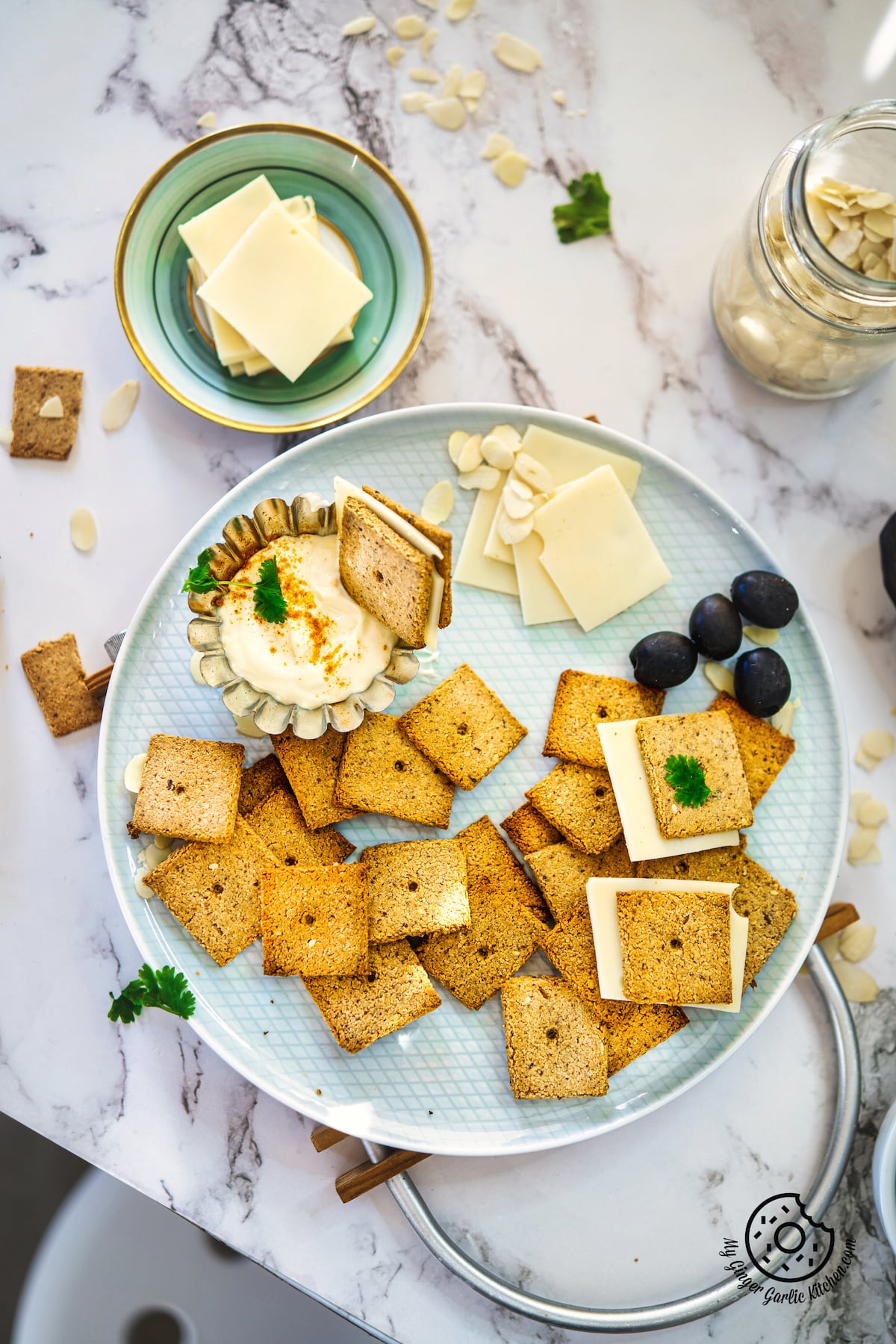 overhead shot of almond flour crackers in a bowl with some vegan cheese slices on the side
