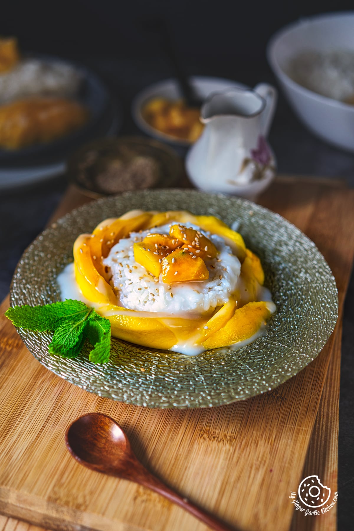 thai mango sticky rice in a dessert plate with mint sprig