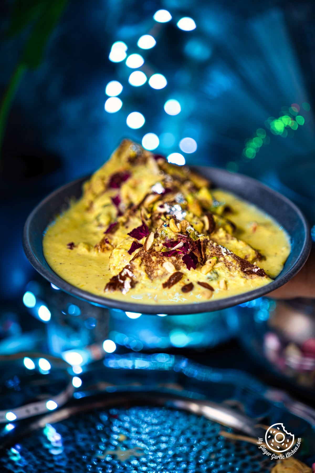 shahi tukda also known as shahi tukra served in a grey ceramic plate with blue bouquet light in the background