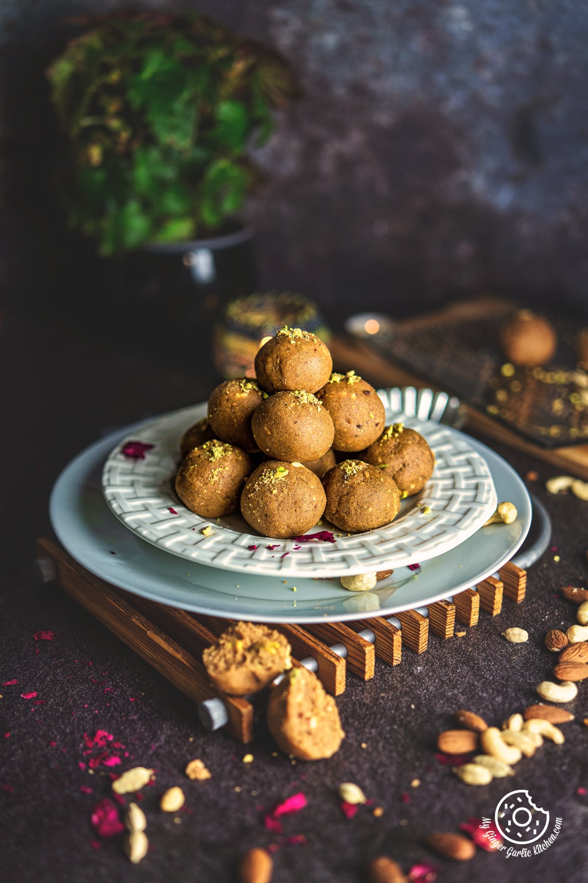 atta ladoo stacked in a white plate with 1 ladoo on the side