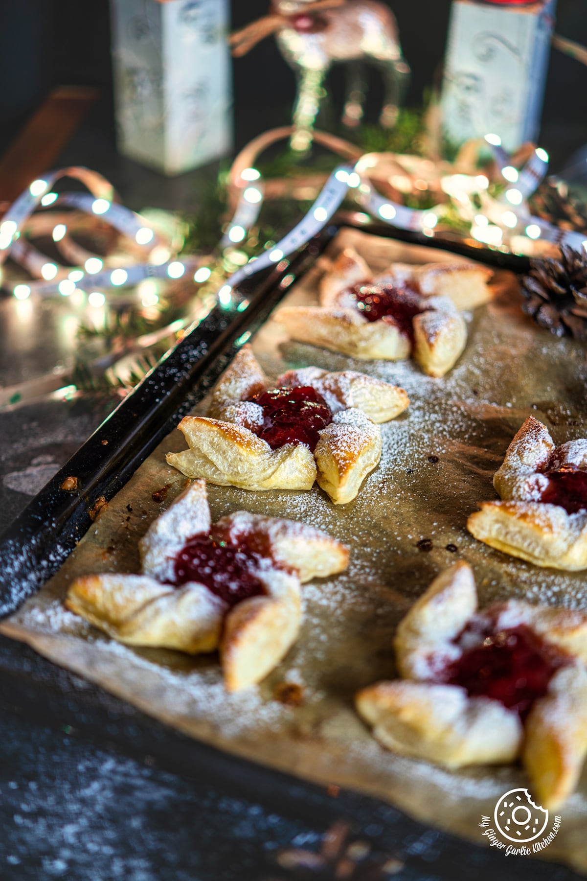 5 Joulutorttu - Finnish Christmas Tarts in a baking sheets with bouquet lights in the background