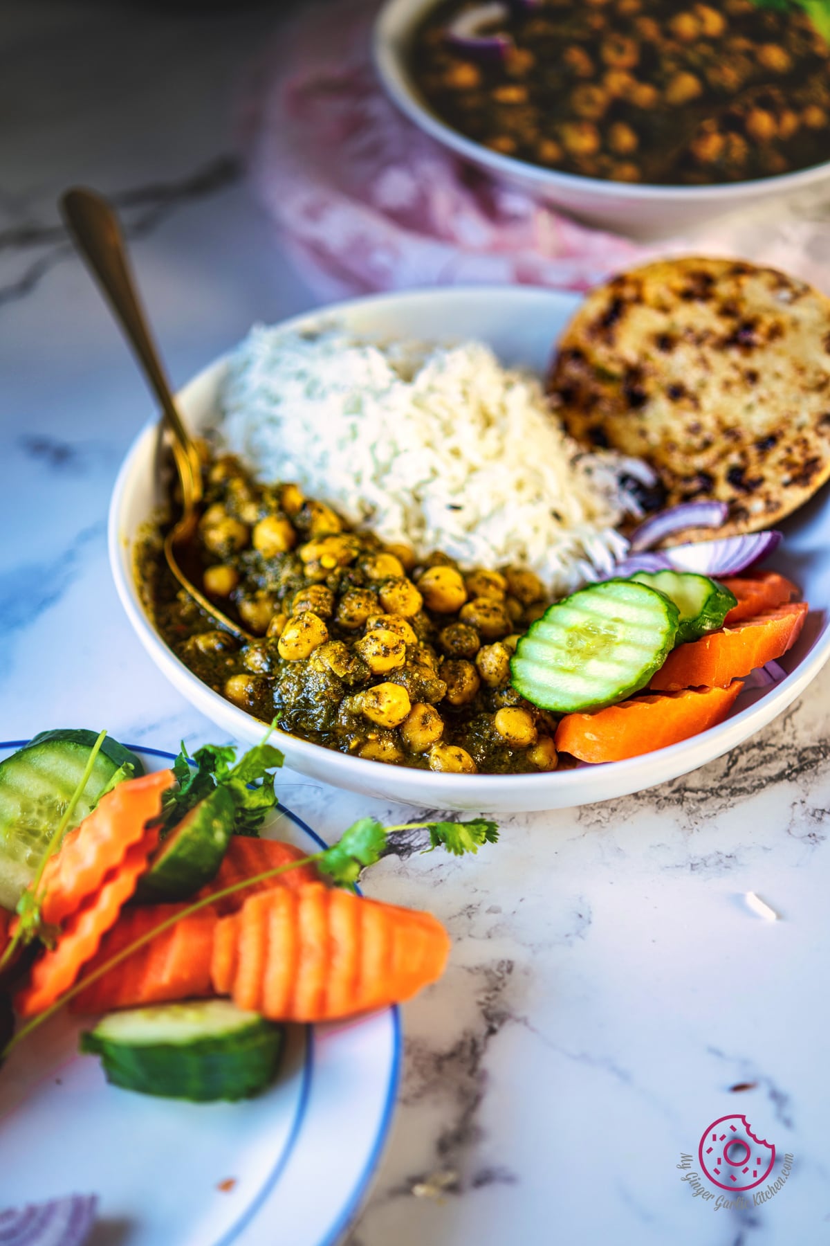 close up photo of a plate with chole palak, rice, roti and salad
