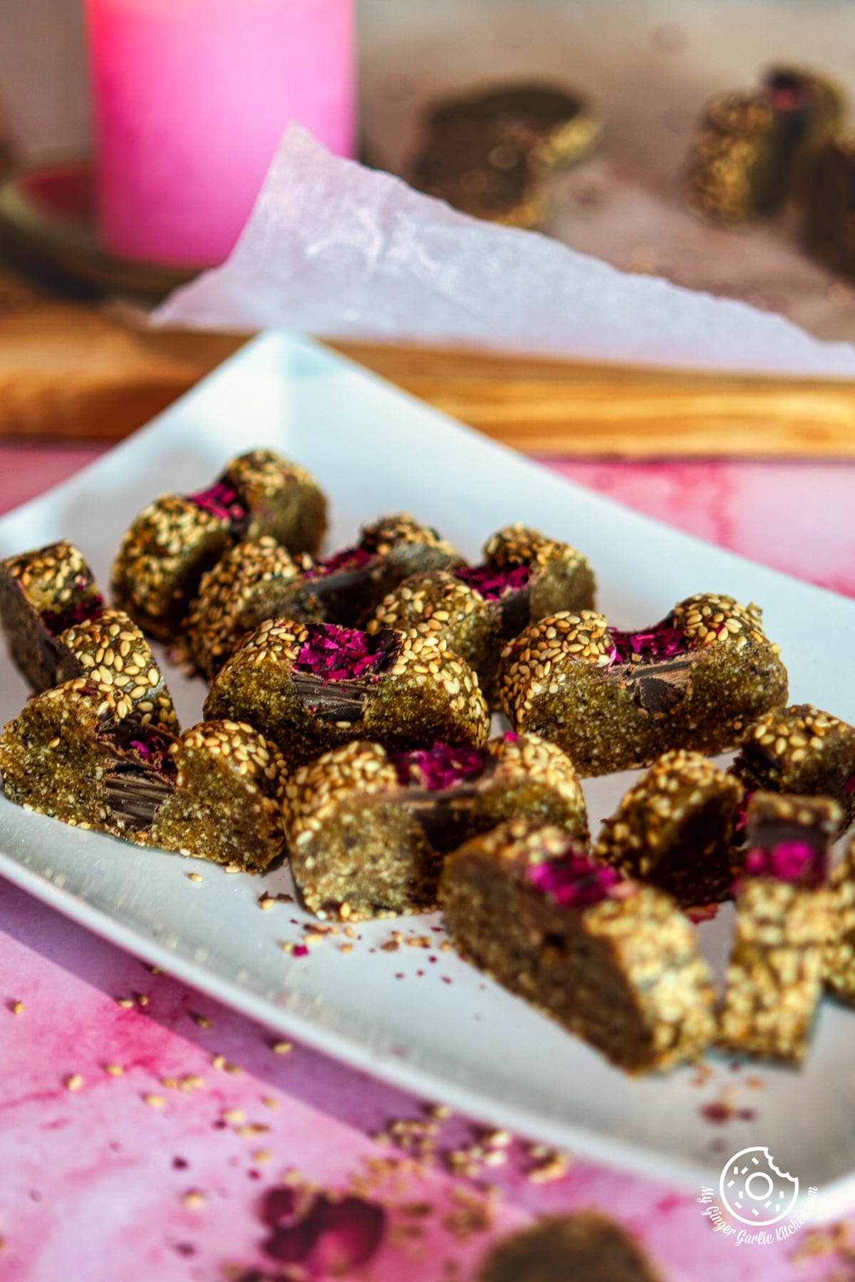 peanut date roll decorated with rose petals in a white rectangle plate