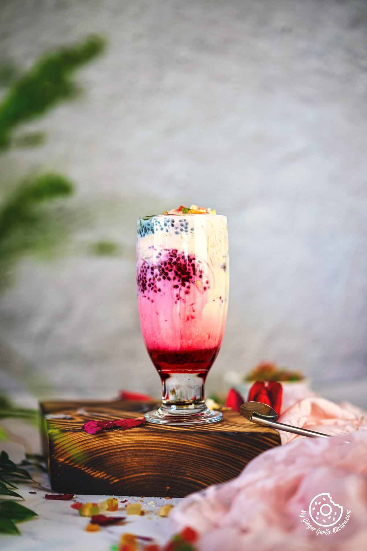 photo of a glass of falooda with ice cream with nuts and rose syrup on top