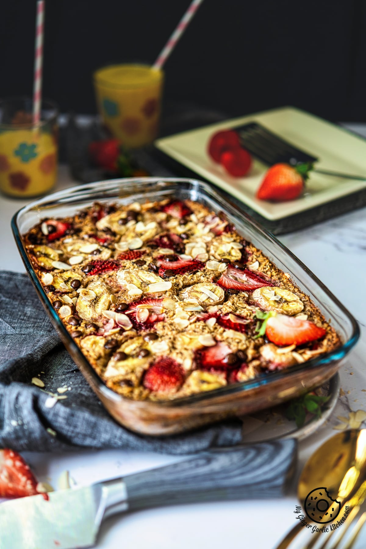 photo of a glass baking dish with a strawberry baked oatmeal topped with strawberries and bananas