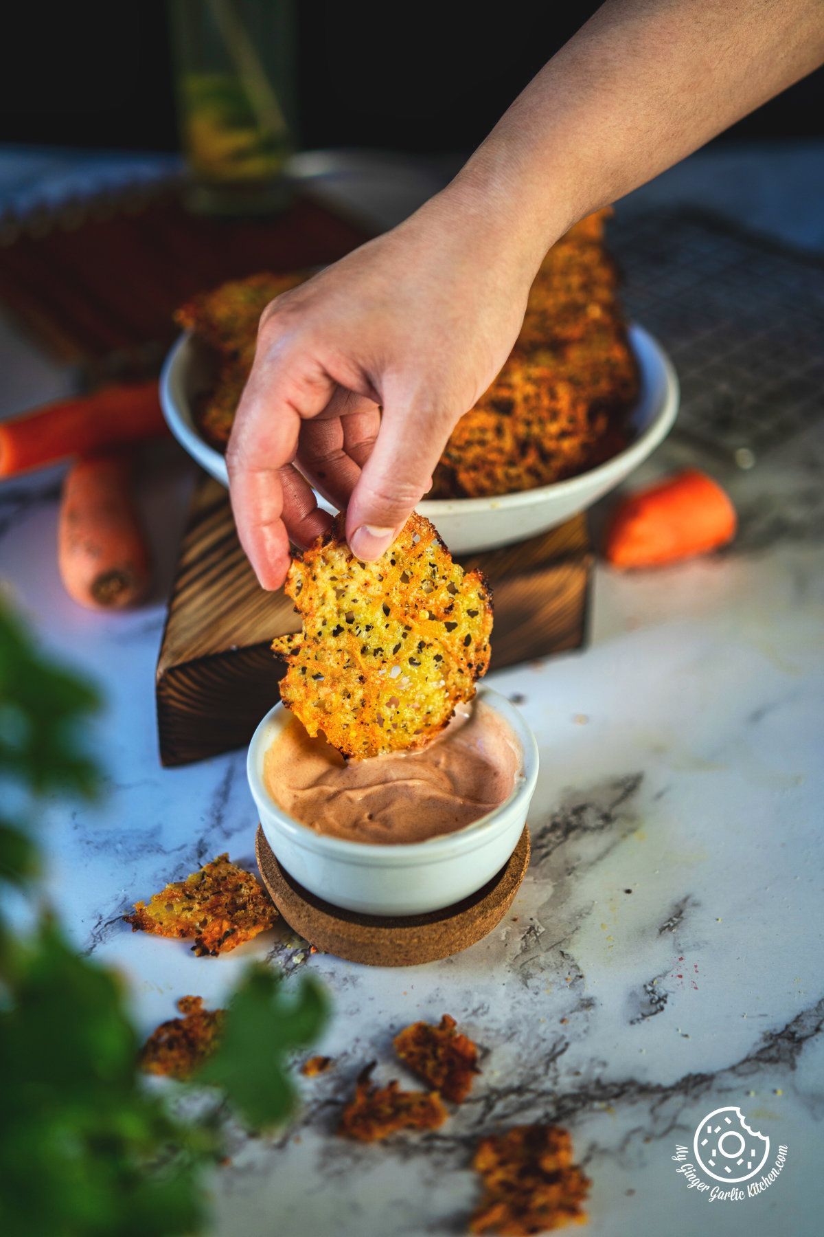  photo of a person dipping a carrot cheese chip into a bowl of dip