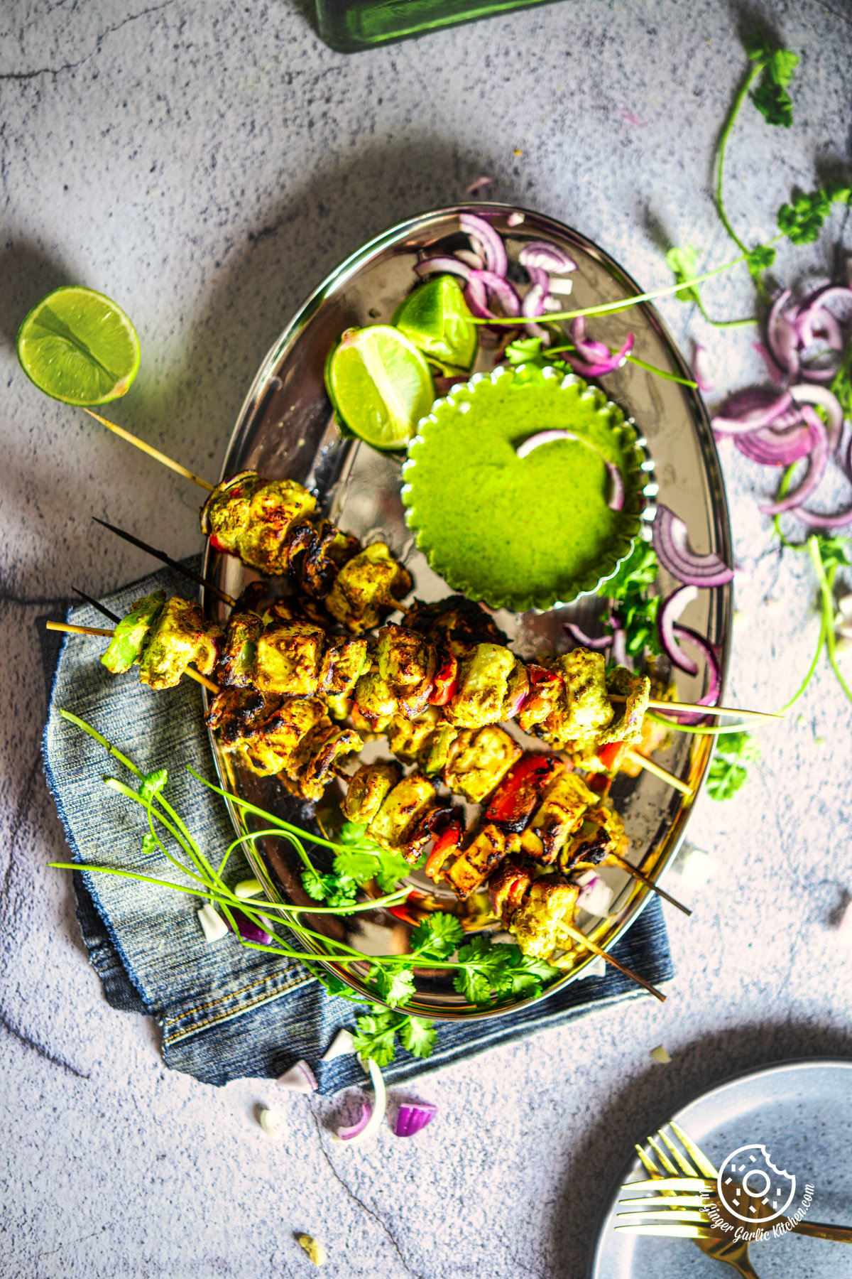 overhead photo of a plate of Hariyali Paneer Tikka with a green sauce and a fork