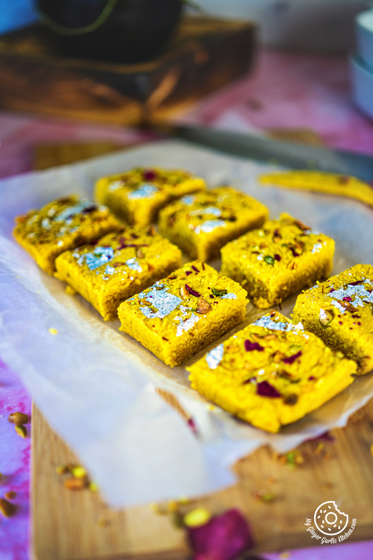 photo of a tray of mango kalakand on top of a wooden cutting board