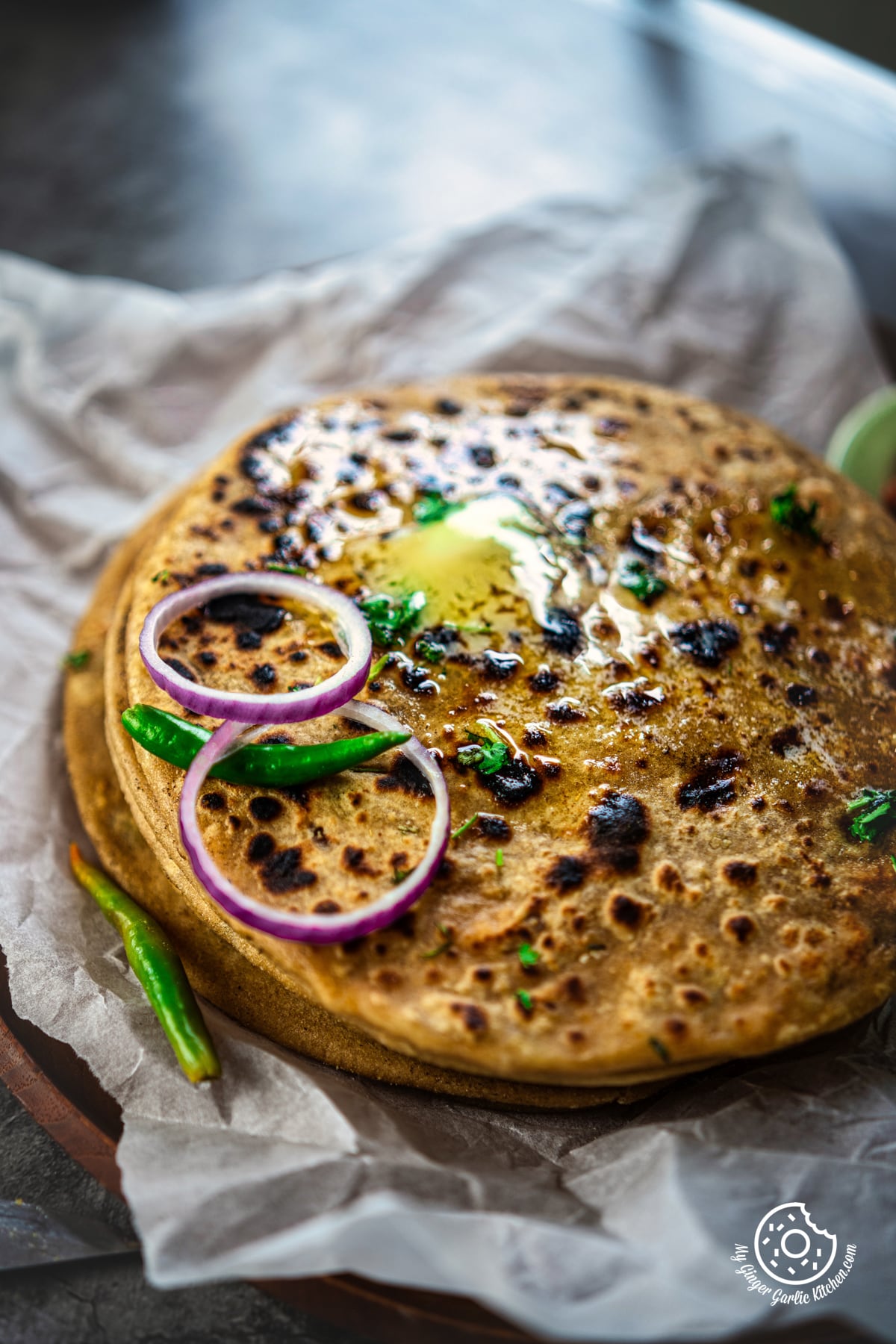 closeup photo of paneer parathas with onions and onions on top
