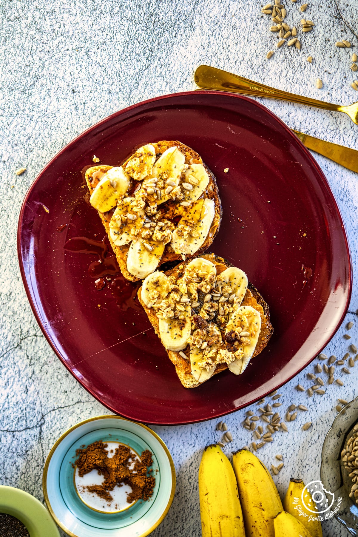 - there are peanut butter banana toast on a red plate on a table and bananas on the side