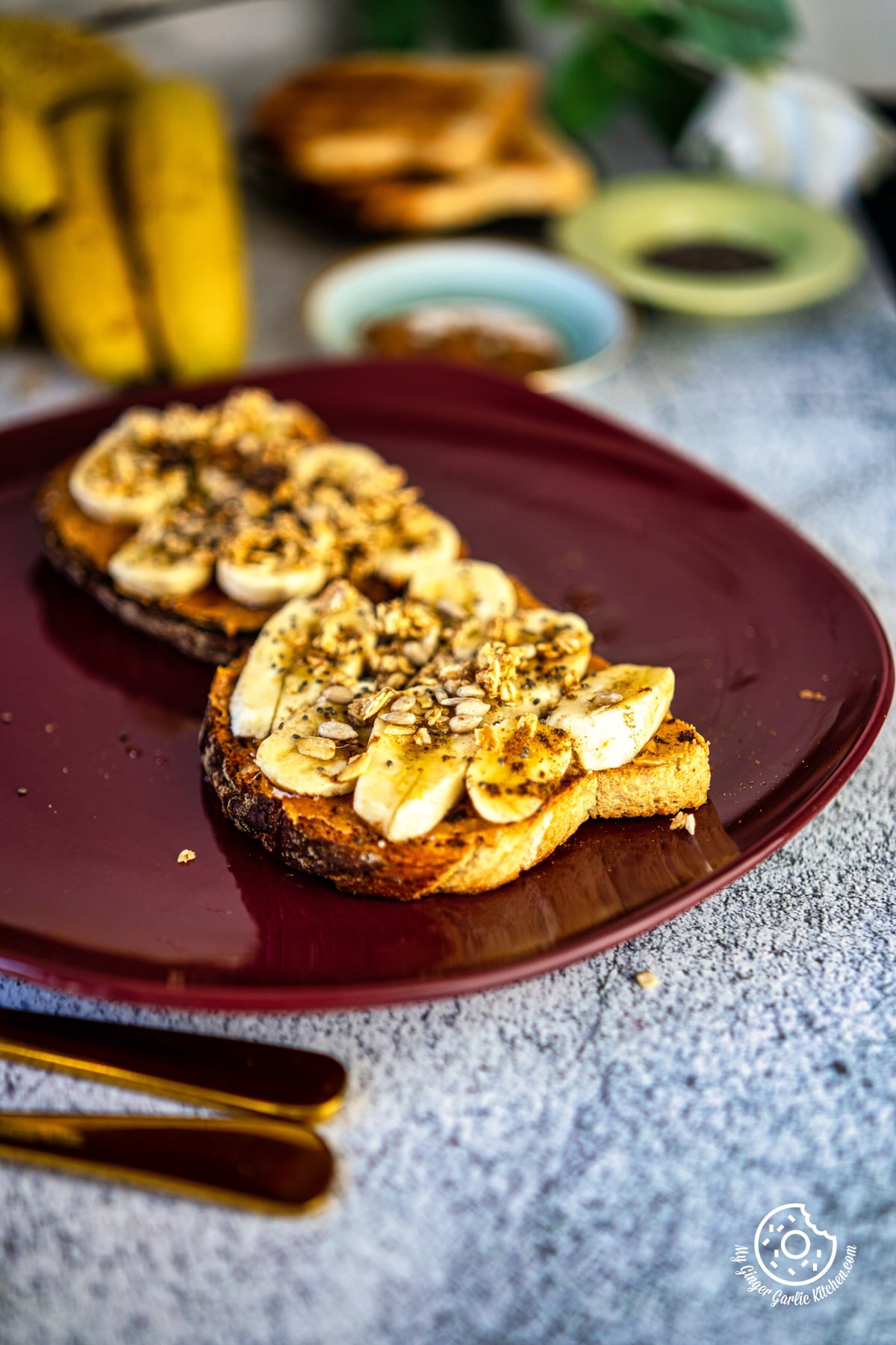 closeup of two pieces of peanut butter banana toasts with bananas on a plate